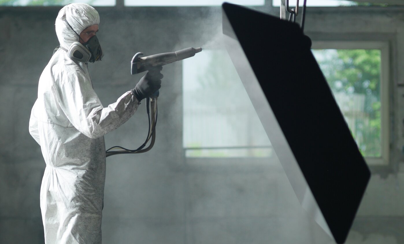 worker sand blasting with protective clothing